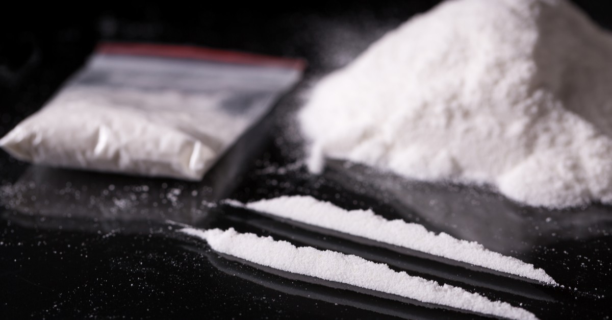 two lines and pile of cocaine on black background-img