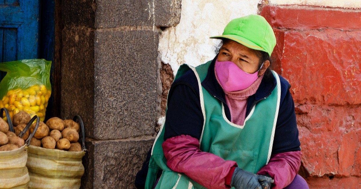 Market seller in respiratory mask during coronavirus pandemic in Cusco, Peru-img