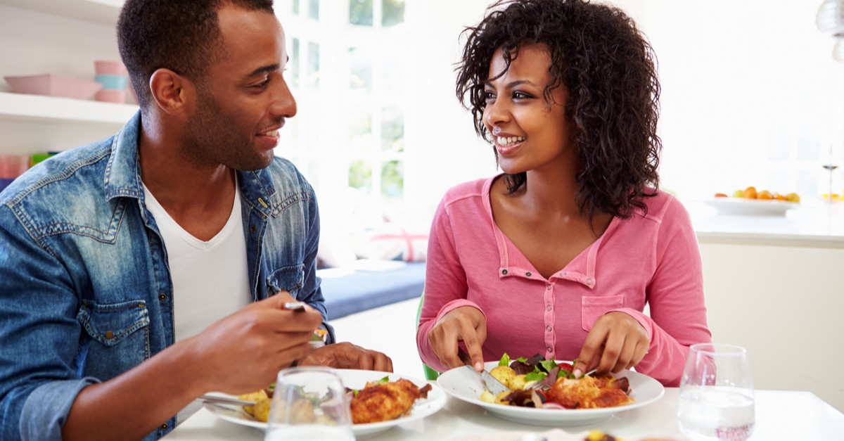Young African American Couple Eating Meal At Home-img