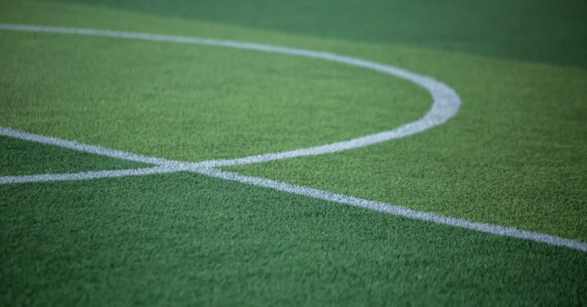 Selective focus to white lines on green artificial grass football fields-img