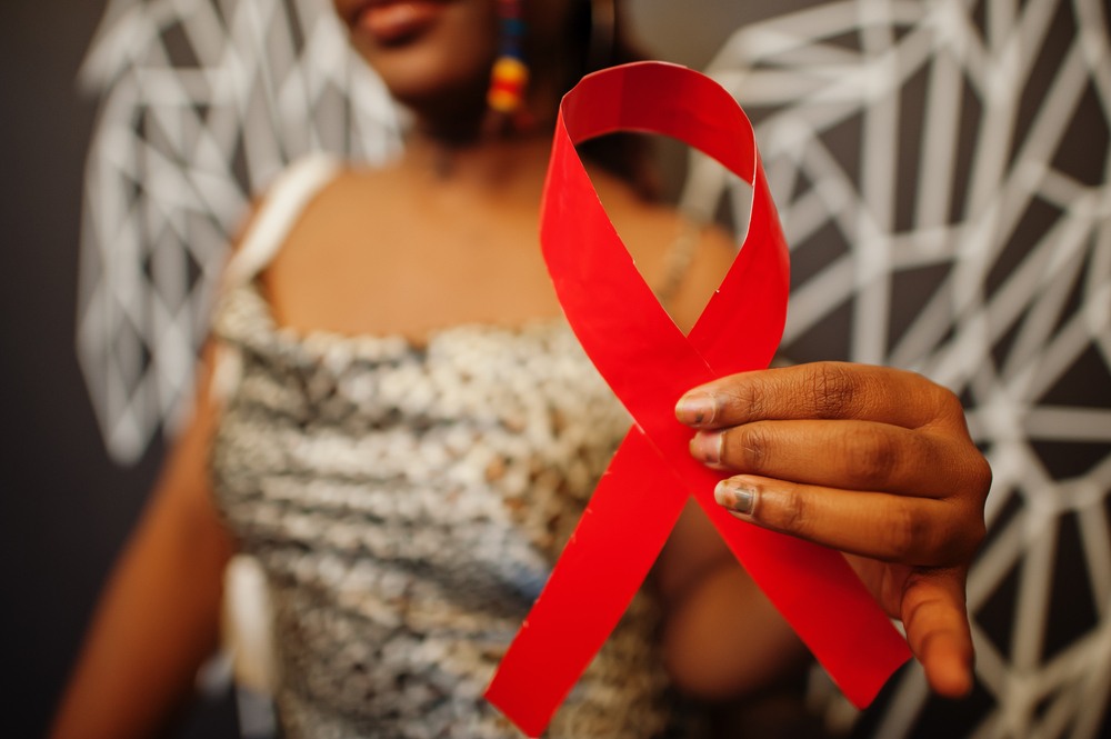 Stylish african american woman hold red ribbon against wall with wings-img