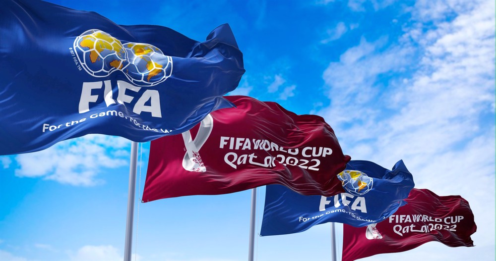 Flags with FIFA and Qatar 2022 World Cup logo waving in the wind-img
