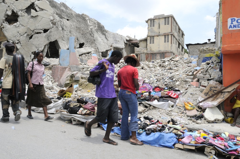 People buying and selling stuffs in front of a collapsed building in Port-Au-Prince-img