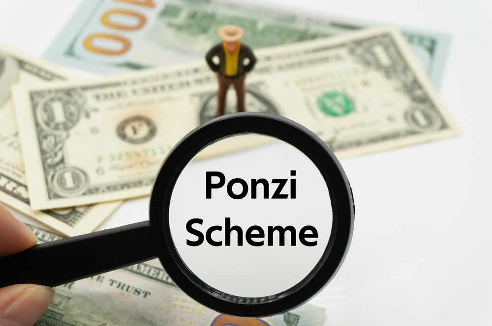 Ponzi Scheme.Magnifying glass showing the words-img