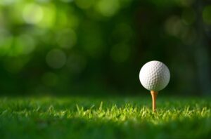 Close-up,Golf,Ball,On,Tee,With,Blur,Green,Bokeh,Background.