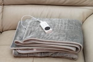 Folded,Electric,Blanket,With,Controller,On,A,Sofa