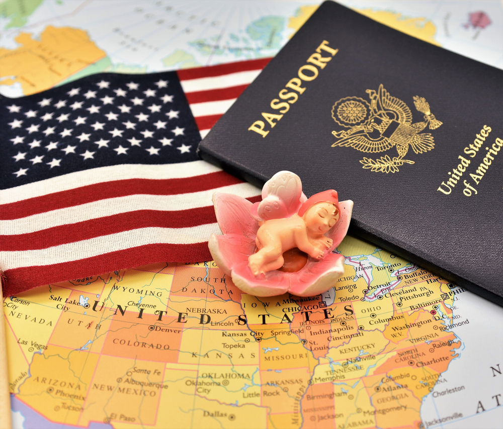 Newborn,Baby,Figurine,,Us,Flag,And,Passport,Are,Placed,Together