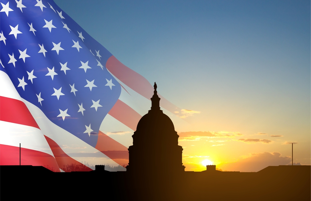 United,States,Capitol,Building,Silhouette,And,Us,Flags,At,Sunset